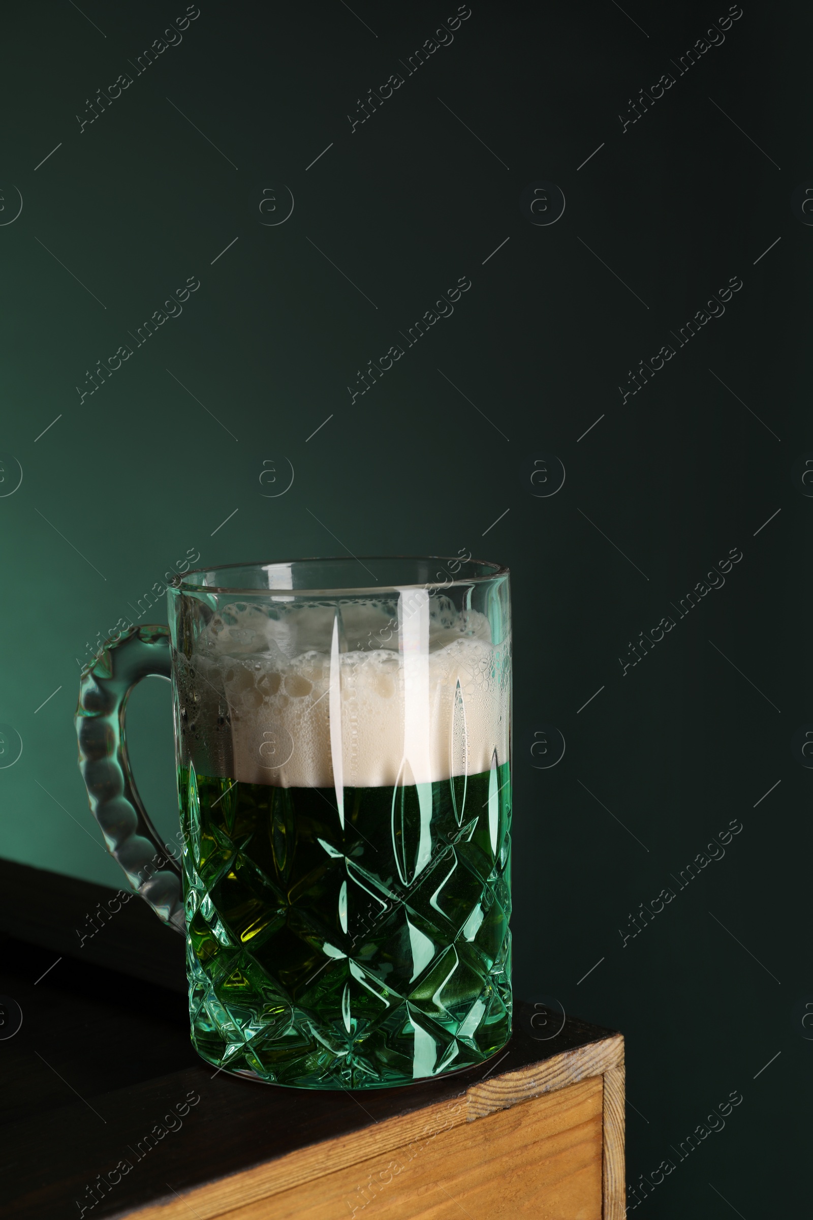 Photo of St. Patrick's day celebration. Green beer on wooden table. Space for text