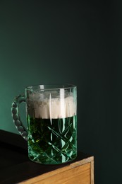 Photo of St. Patrick's day celebration. Green beer on wooden table. Space for text