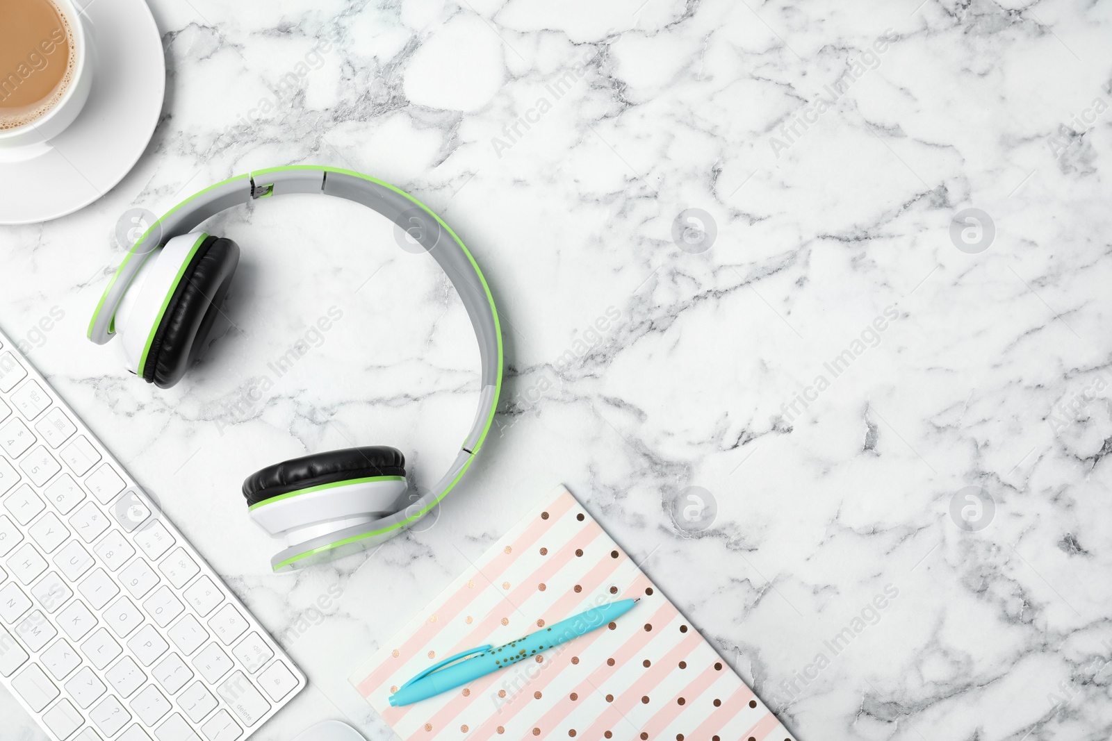 Photo of Flat lay composition with headphones, computer keyboard and space for text on marble background