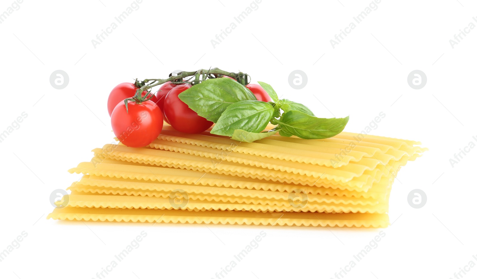 Photo of Uncooked lasagna sheets, cherry tomatoes and basil isolated on white