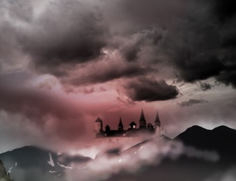 Image of Fantasy world. Mystical castle and mountains covering with fog in night