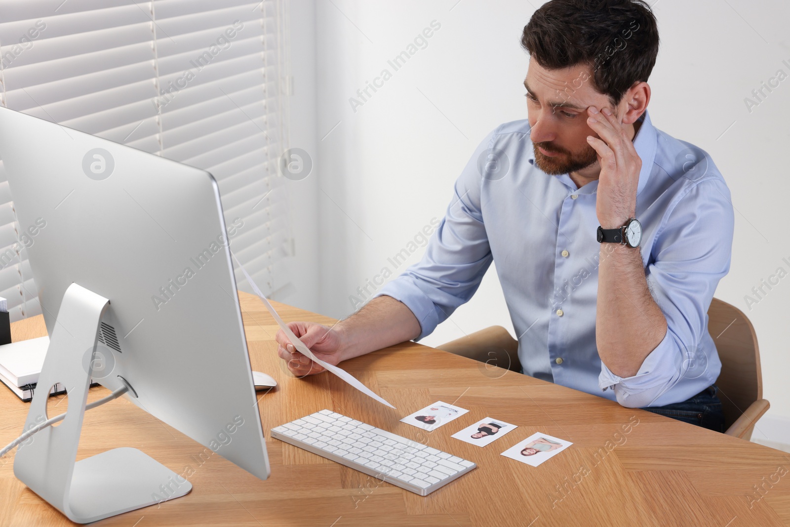 Photo of Human resources manager reading applicant's resume in office