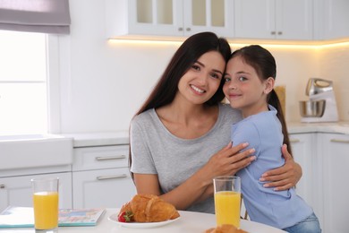 Photo of Portrait of happy mother and daughter in kitchen. Single parenting