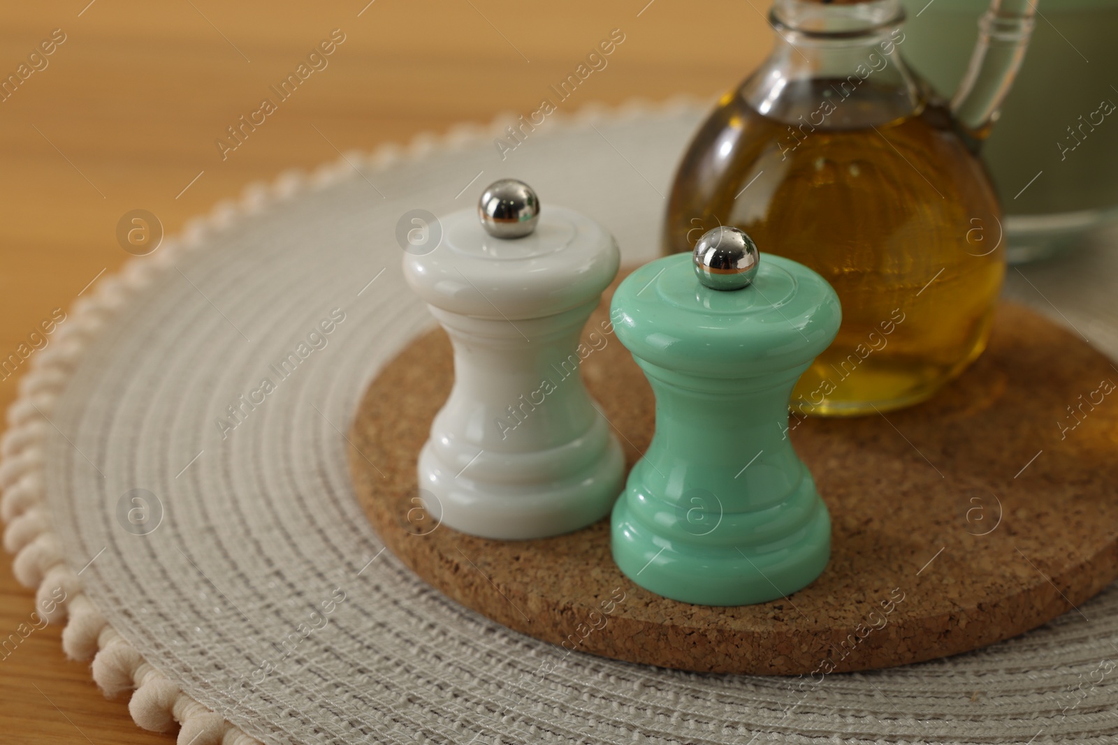 Photo of Salt and pepper shakers and bottle of oil on wooden table