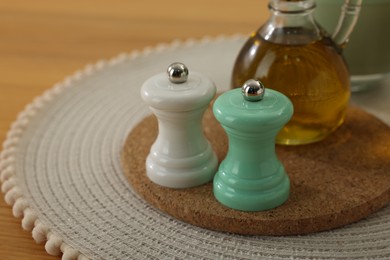 Salt and pepper shakers and bottle of oil on wooden table