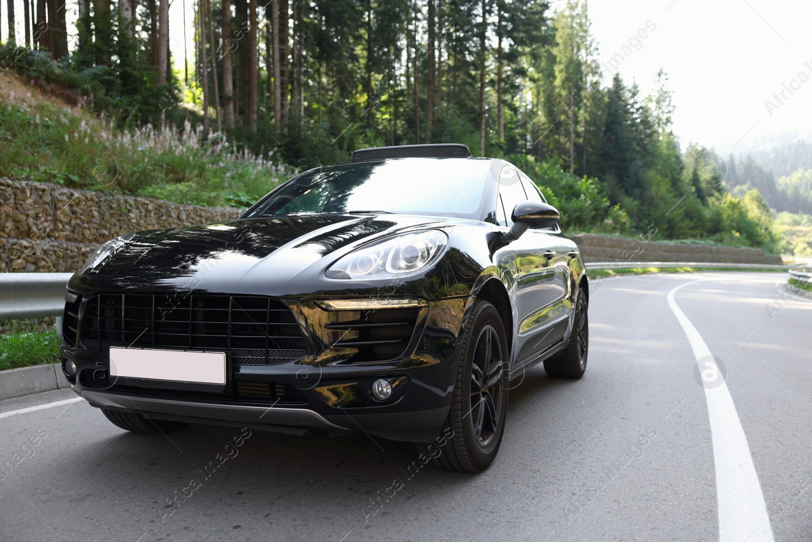 Photo of Modern black car on asphalt road outdoors, space for text