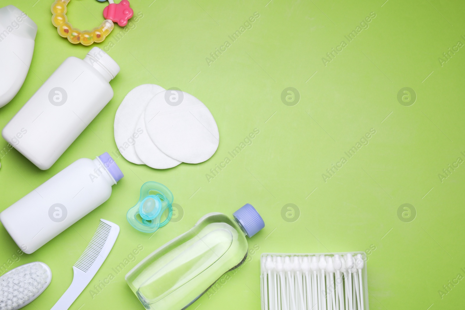 Photo of Flat lay composition with baby care products and accessories on light green background, space for text