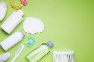 Flat lay composition with baby care products and accessories on light green background, space for text