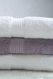Photo of Stack of folded terry towels on grey background, closeup