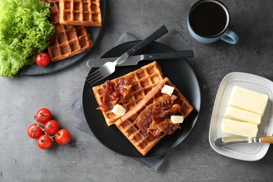 Tasty Belgian waffles served with bacon, butter and coffee on grey table, flat lay