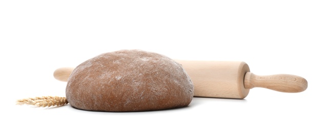 Photo of Raw rye dough, rolling pin and spikes on white background