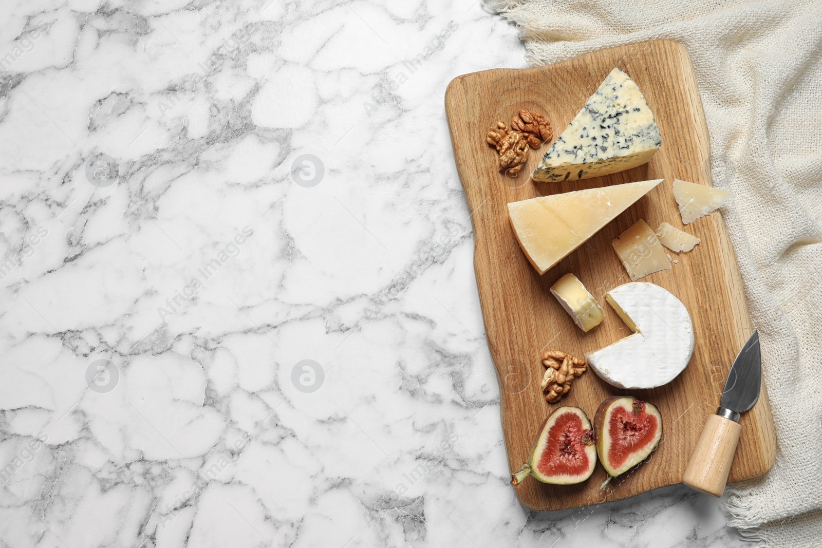 Photo of Different delicious cheeses served on marble table, top view. Space for text