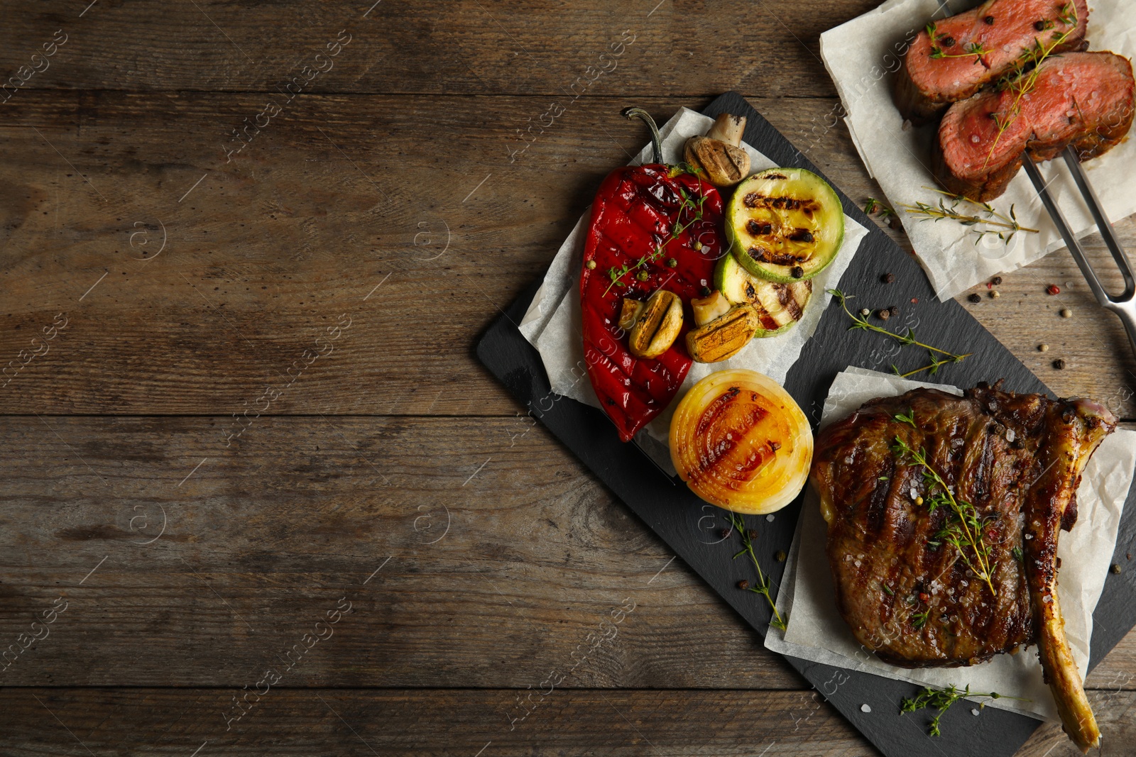 Photo of Flat lay composition with grilled meat on wooden table. Space for text