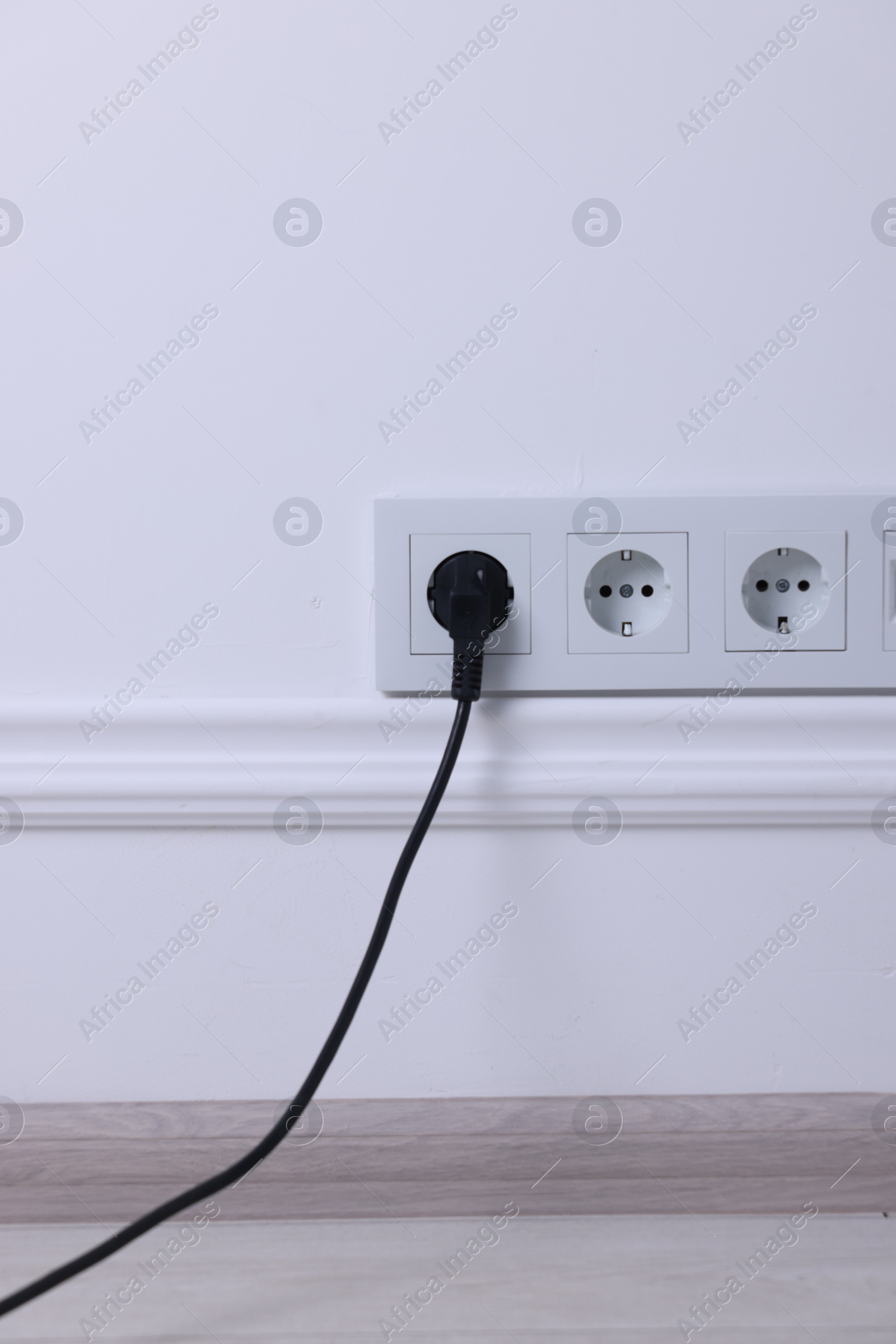 Photo of Power sockets and electric plug on white wall