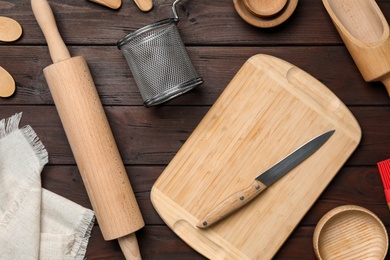 Set of modern cooking utensils on brown wooden table, flat lay