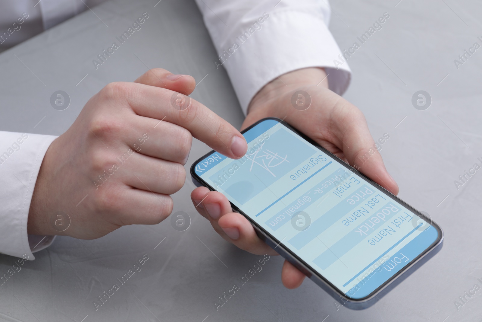 Image of Electronic signature. Man using mobile phone at grey table, closeup