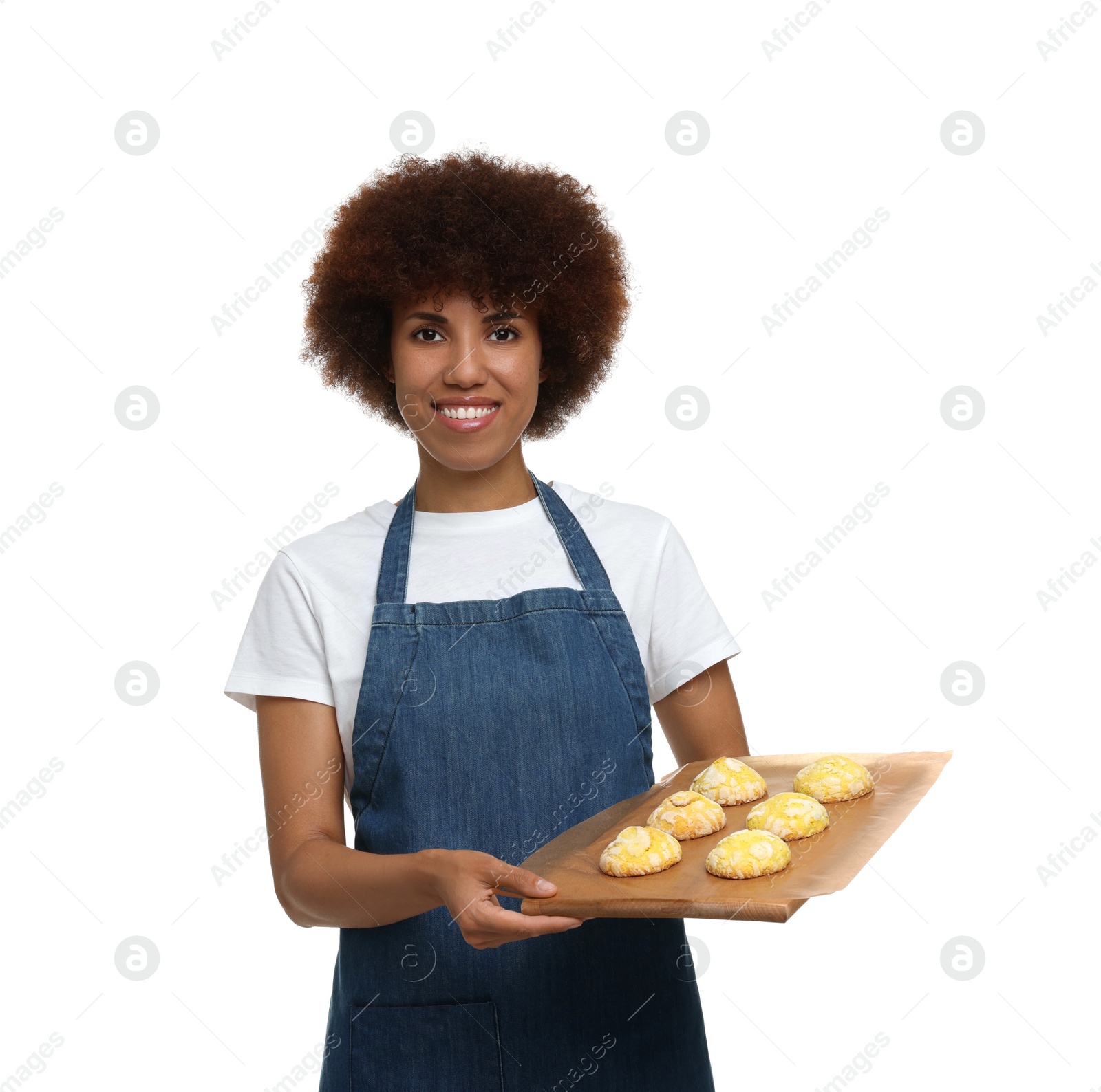 Photo of Happy young woman in apron holding board with cookies on white background