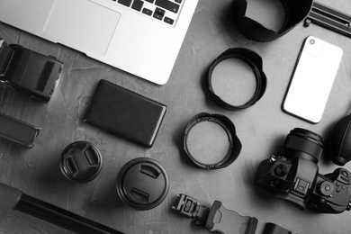 Flat lay composition with camera and video production equipment on grey stone background