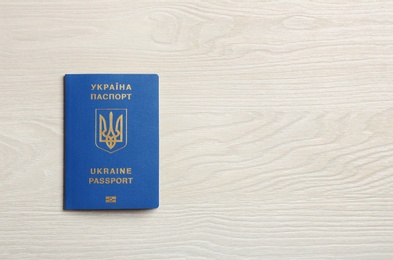 Photo of Ukrainian travel passport on wooden background, top view with space for text. International relationships