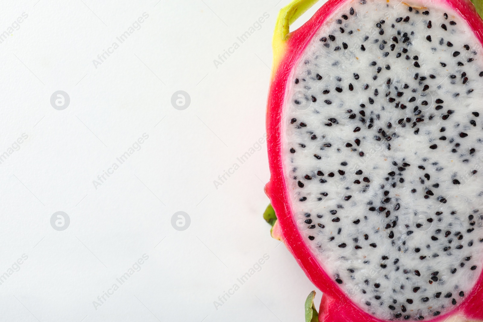 Photo of Top view of cut dragon fruit (pitahaya) on white background, closeup. Space for text