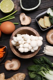 Photo of Cooking delicious ramen soup. Different ingredients on wooden table, flat lay