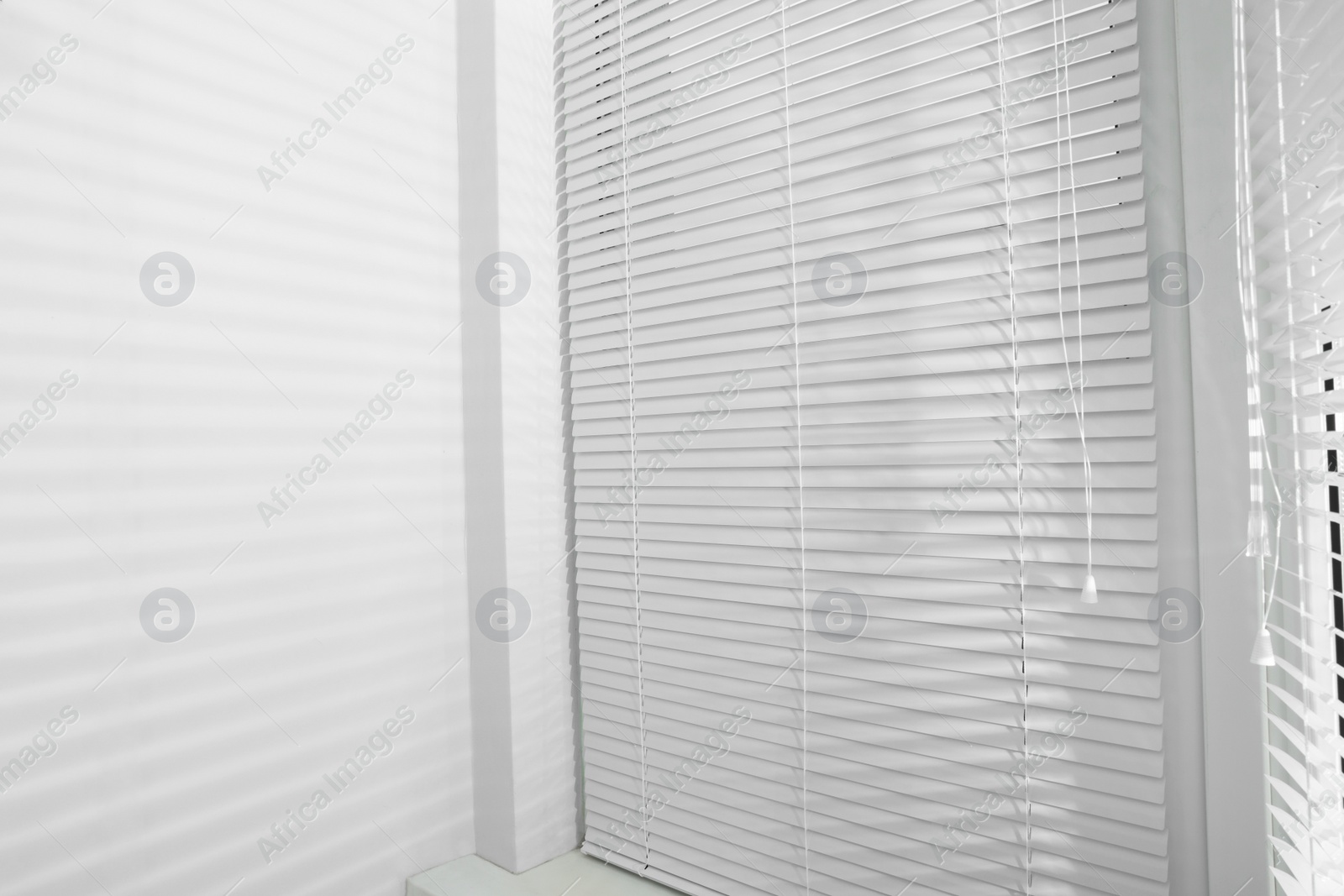 Photo of Stylish window with horizontal blinds in room