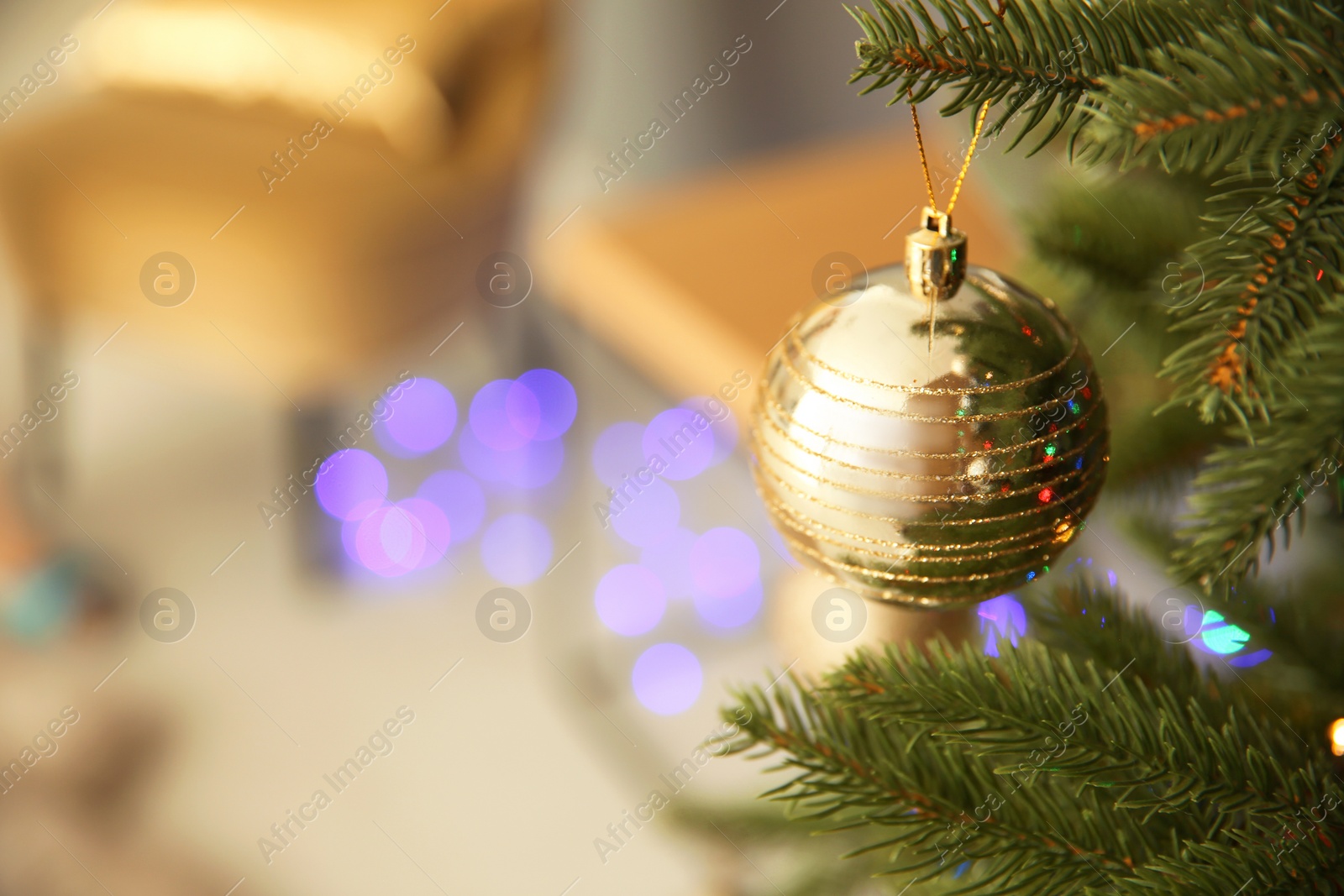 Photo of Shiny decoration on Christmas tree indoors, closeup