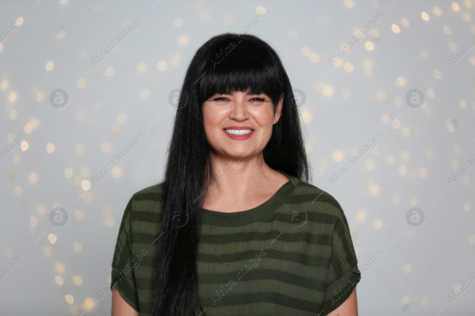 Photo of Portrait of mature woman against defocused lights