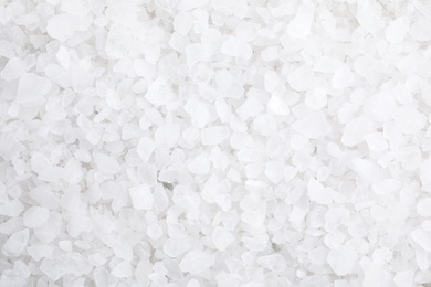 Photo of White sea salt as background, top view. Spa treatment