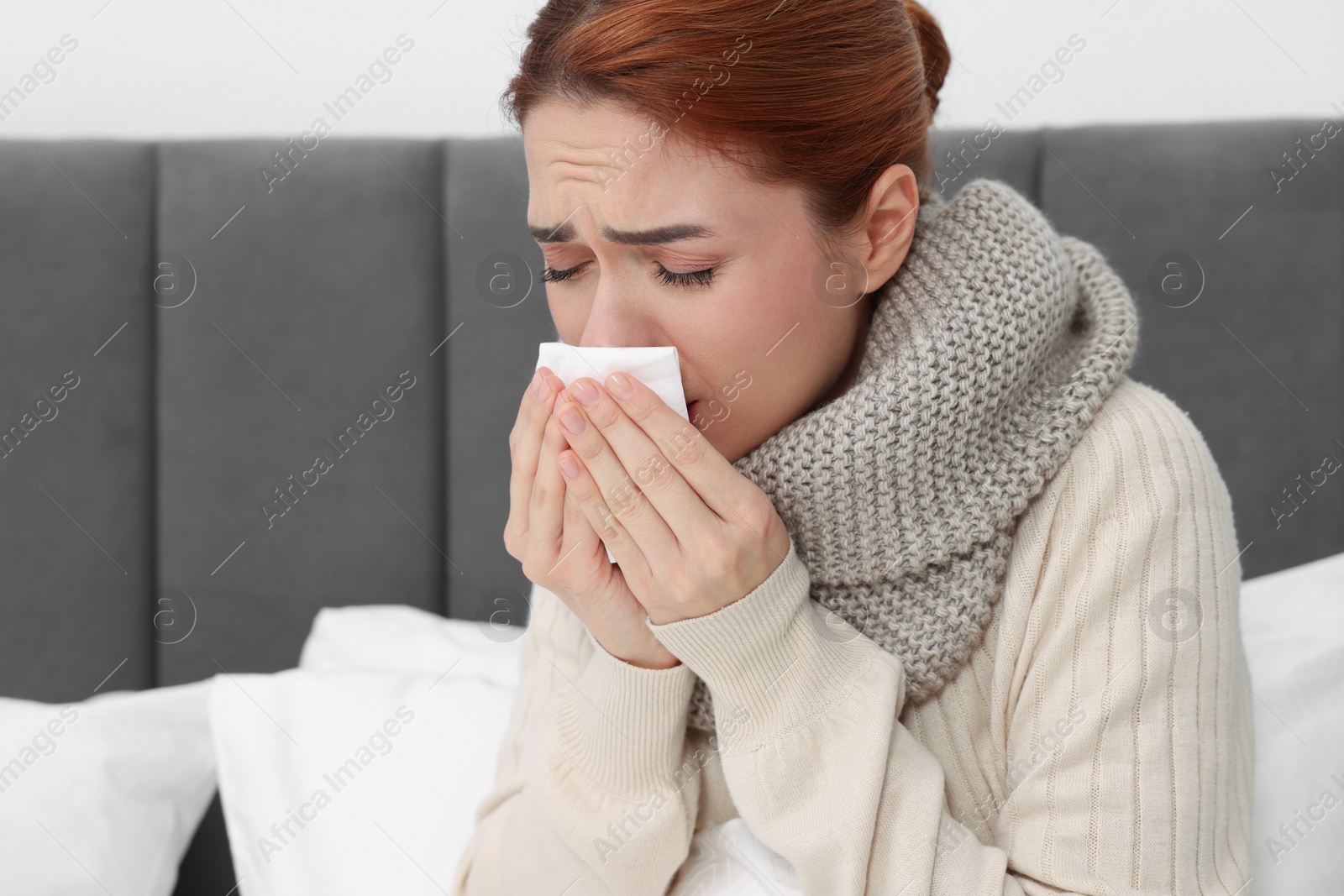 Photo of Woman with tissue coughing on bed, space for text. Cold symptoms