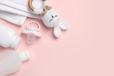 Photo of Flat lay composition with pacifier and other baby stuff on pink background. Space for text