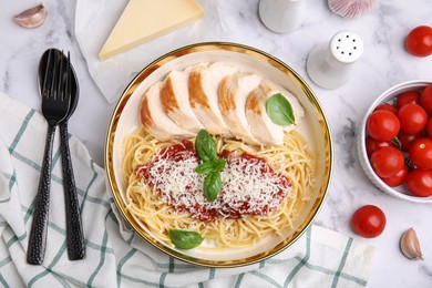 Photo of Delicious pasta with tomato sauce, chicken and parmesan cheese on white marble table, flat lay