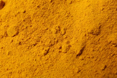 Photo of Aromatic turmeric powder as background, closeup view