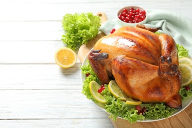 Delicious roasted turkey for traditional festive dinner on wooden table, space for text