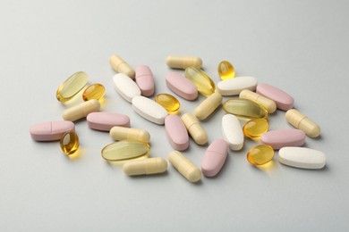 Different vitamin pills on light grey background. Health supplement