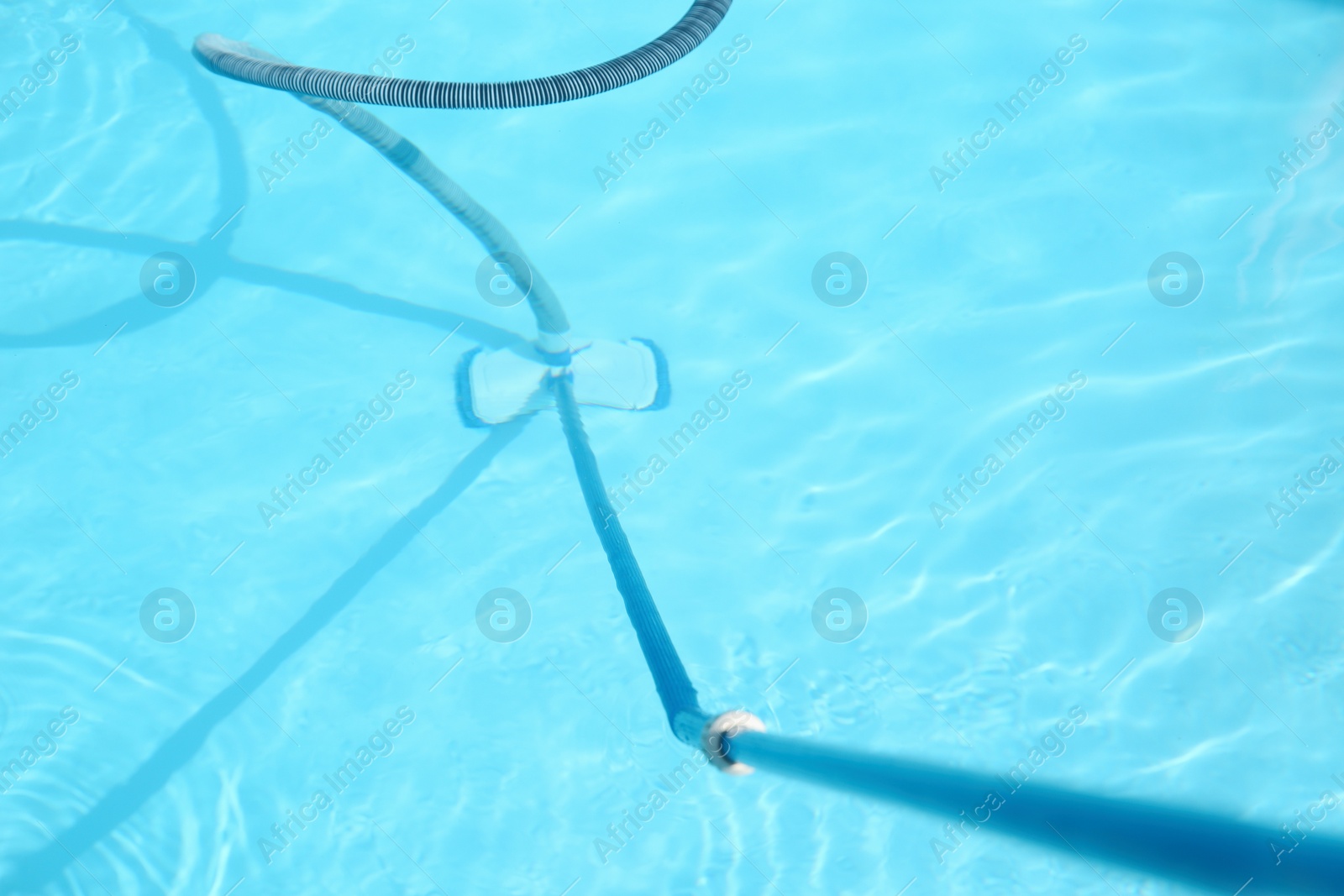 Photo of Cleaning outdoor swimming pool with underwater vacuum