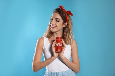 Photo of MYKOLAIV, UKRAINE - NOVEMBER 28, 2018: Young woman with Coca-Cola can on color background