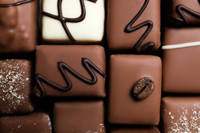 Photo of Different delicious chocolate candies as background, top view