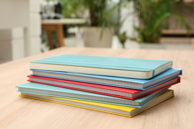Stack of colorful planners on wooden table indoors
