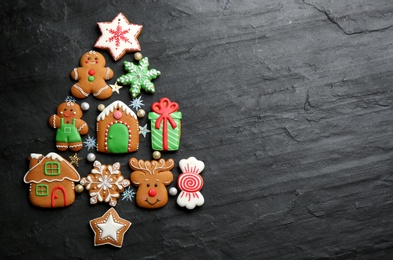 Christmas tree shape made of delicious gingerbread cookies on black table, flat lay. Space for text