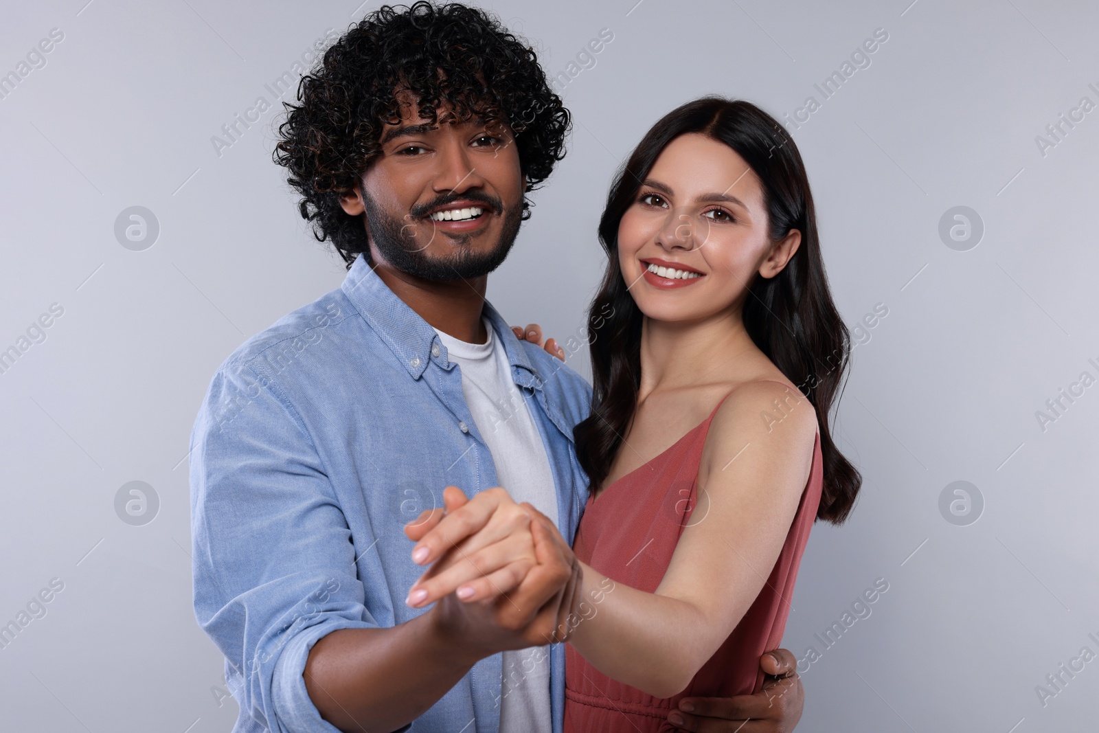 Photo of International dating. Happy couple dancing on light grey background