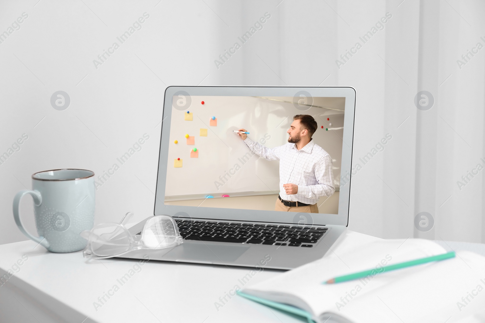 Image of Modern laptop on white desk indoors. Online learning