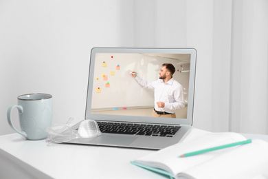 Image of Modern laptop on white desk indoors. Online learning