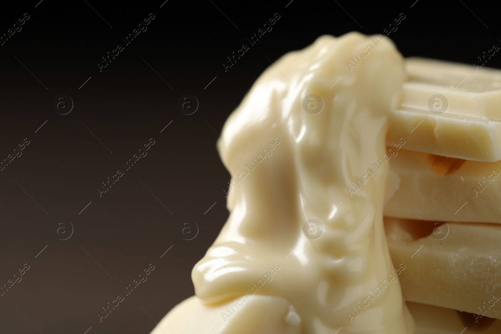 Photo of Pieces of white chocolate and tasty paste against blurred background, closeup. Space for text