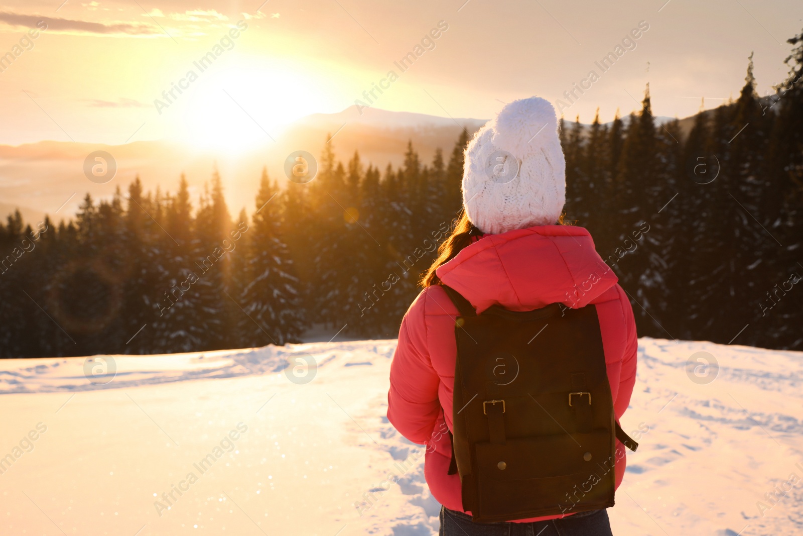 Photo of Young woman enjoying beautiful sunset outdoors, space for text. Winter vacation