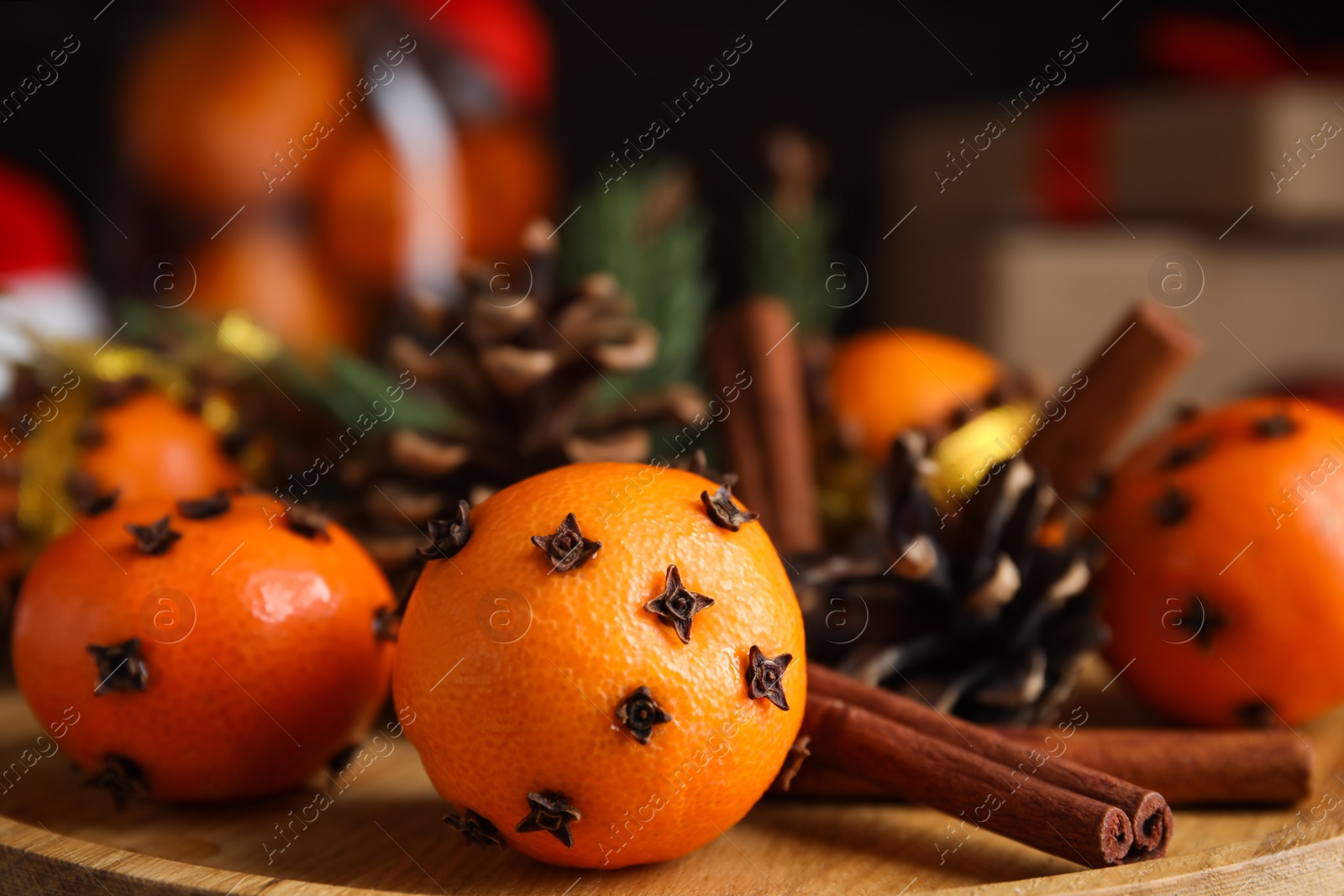 Photo of Tangerine pomander balls on wooden board, closeup