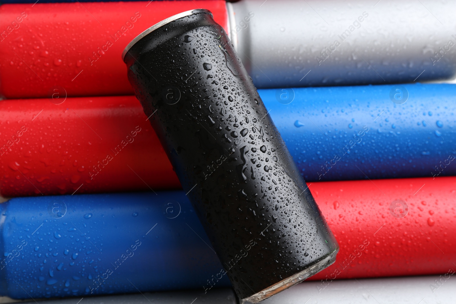 Photo of Energy drinks in wet cans as background, top view