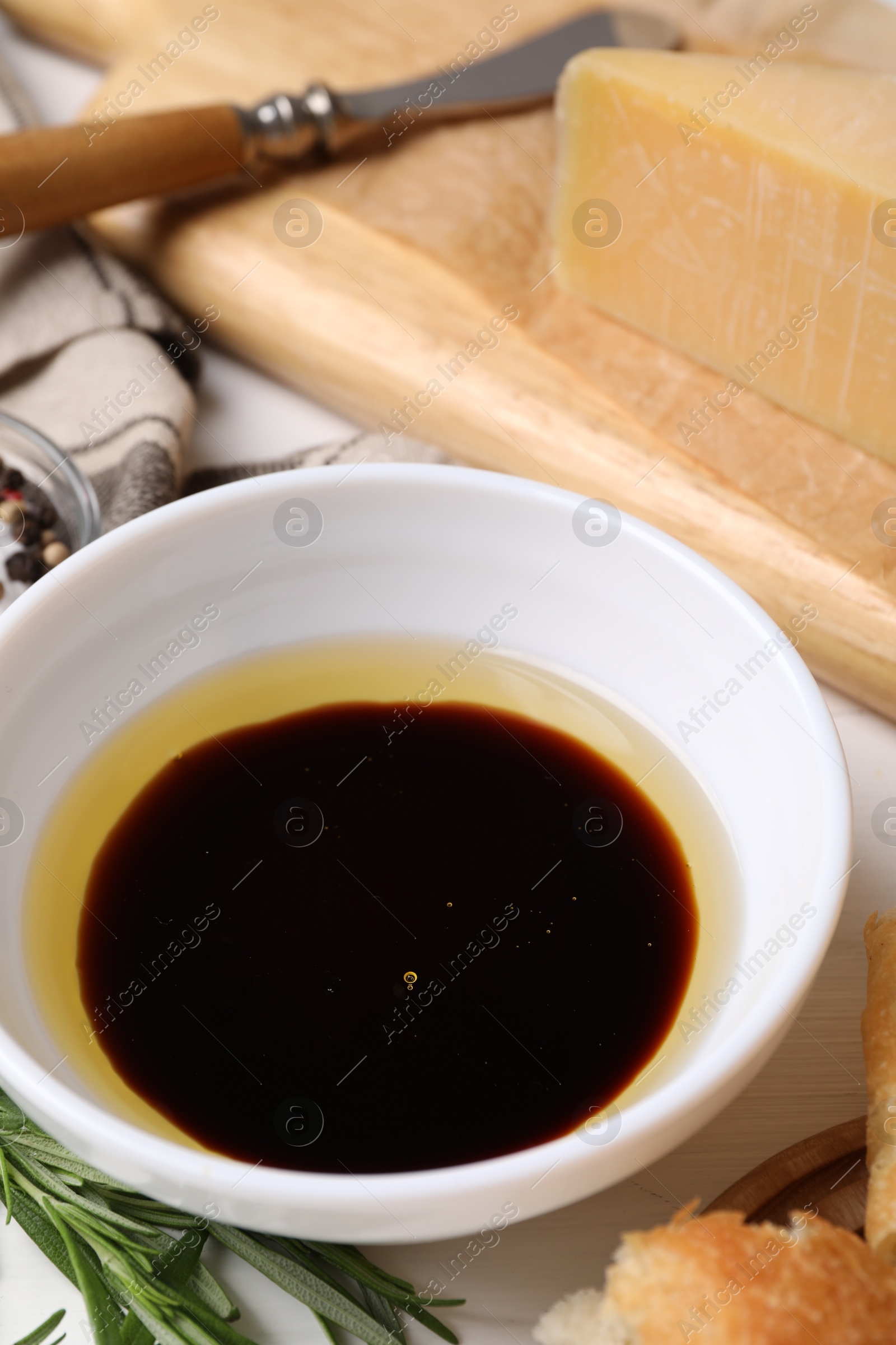 Photo of Bowl of balsamic vinegar with oil on table, closeup