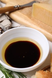 Photo of Bowl of balsamic vinegar with oil on table, closeup