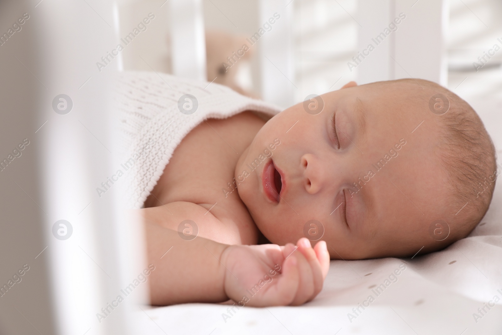 Photo of Cute little baby sleeping in crib, closeup